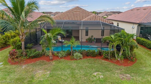 view of pool with a lawn and a lanai