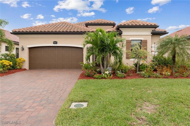 mediterranean / spanish house featuring a front lawn and a garage