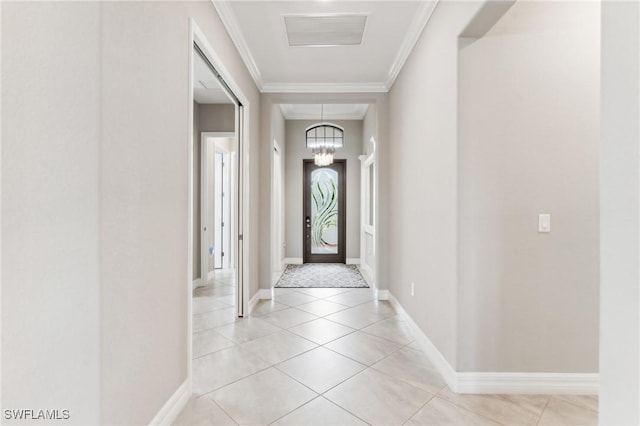 tiled entrance foyer featuring crown molding and a chandelier