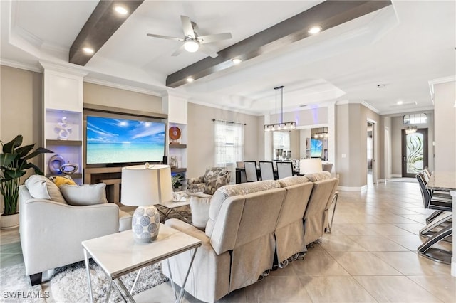 living room with ceiling fan, light tile patterned flooring, a raised ceiling, and crown molding