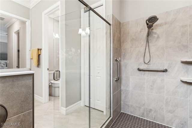 bathroom featuring ornamental molding, a shower with shower door, and toilet