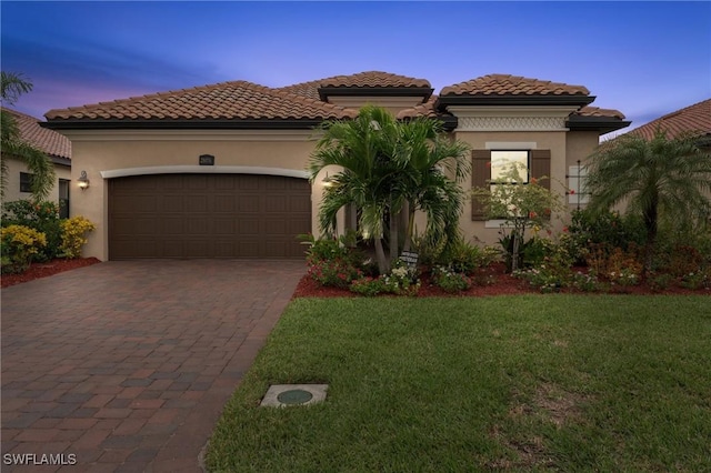 mediterranean / spanish house featuring a lawn and a garage