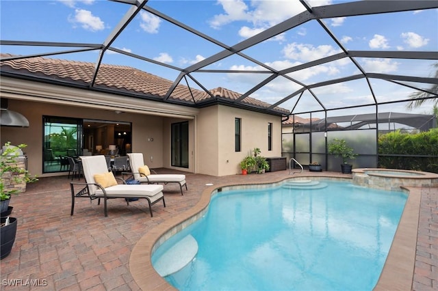 view of swimming pool with an in ground hot tub, a patio, and glass enclosure