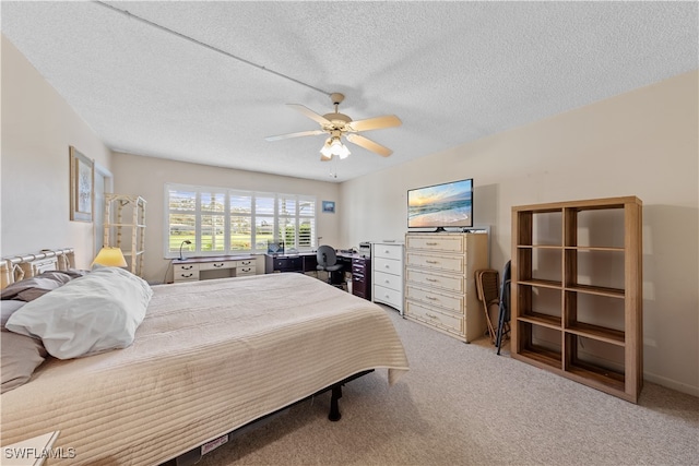 carpeted bedroom with a textured ceiling and ceiling fan