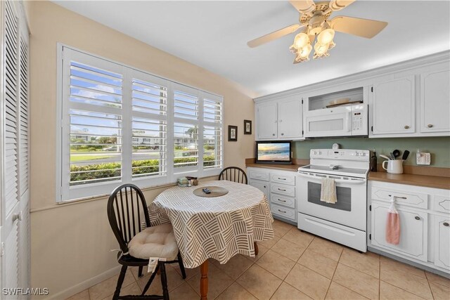 kitchen with white cabinets, ceiling fan, light tile patterned floors, and white appliances