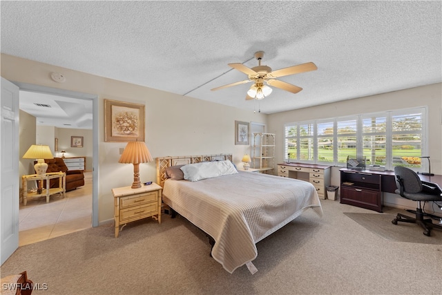 bedroom featuring ceiling fan, light carpet, and a textured ceiling