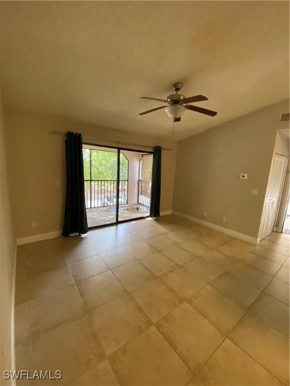 tiled spare room with ceiling fan