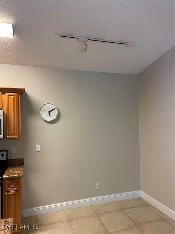 interior space featuring rail lighting and a textured ceiling