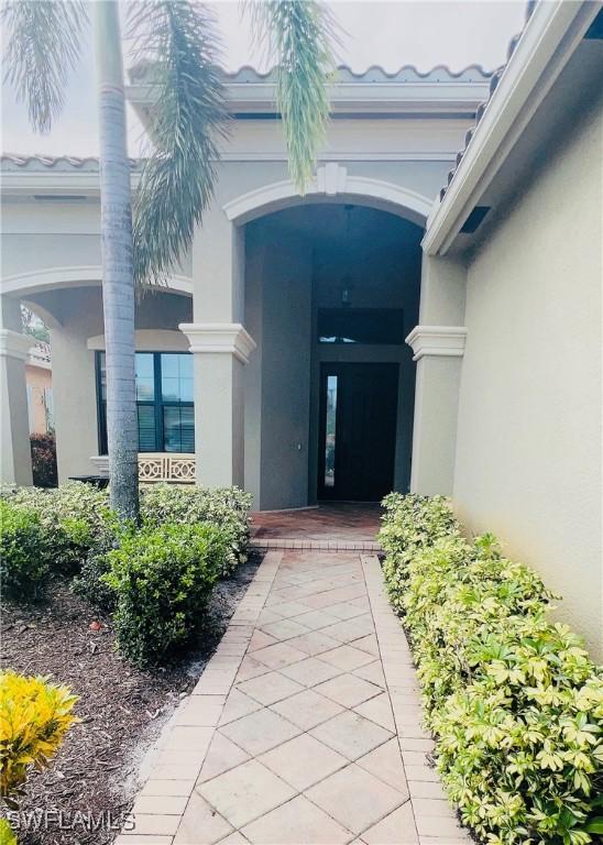 3195 Pacific Dr, Naples, FL 34119 - property entrance featuring stucco siding