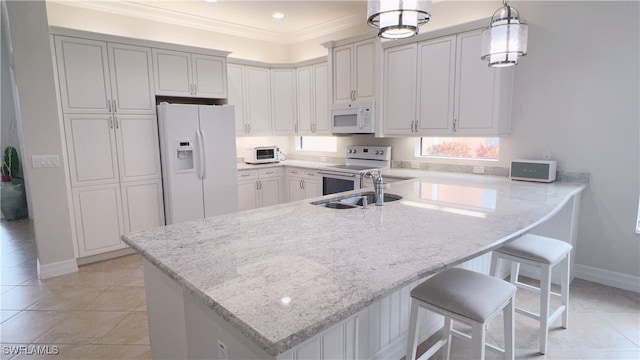 kitchen featuring white appliances, kitchen peninsula, pendant lighting, ornamental molding, and a breakfast bar area