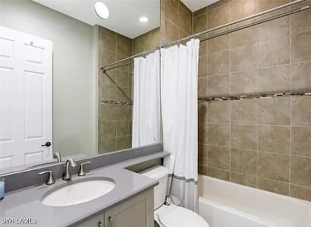 full bathroom featuring vanity, shower / tub combo with curtain, and toilet