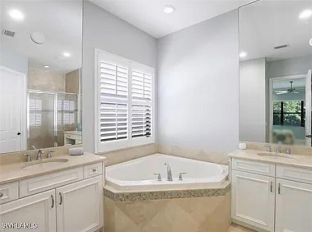 bathroom featuring vanity, ceiling fan, and plus walk in shower