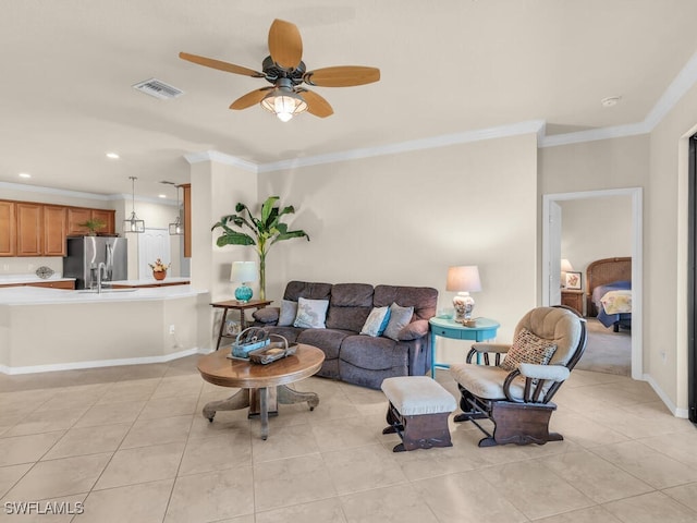 living area featuring light tile patterned floors, ornamental molding, visible vents, and baseboards