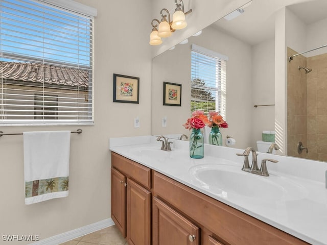 full bathroom featuring toilet, double vanity, a sink, and tile patterned floors