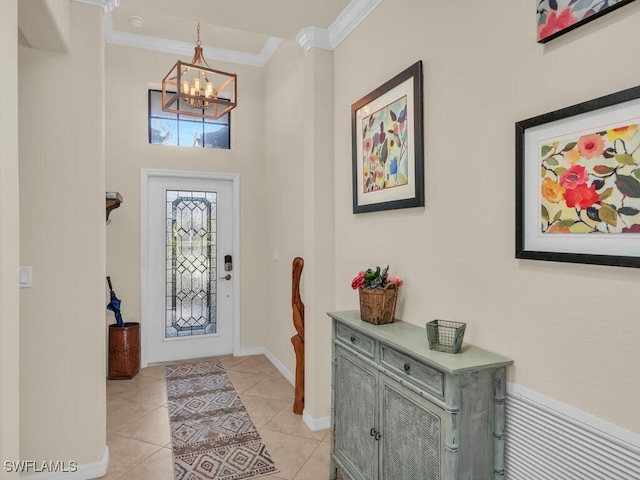 entrance foyer with ornamental molding, a chandelier, baseboards, and light tile patterned floors