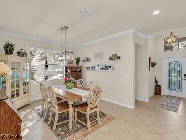 dining area with light tile patterned floors, baseboards, visible vents, and crown molding