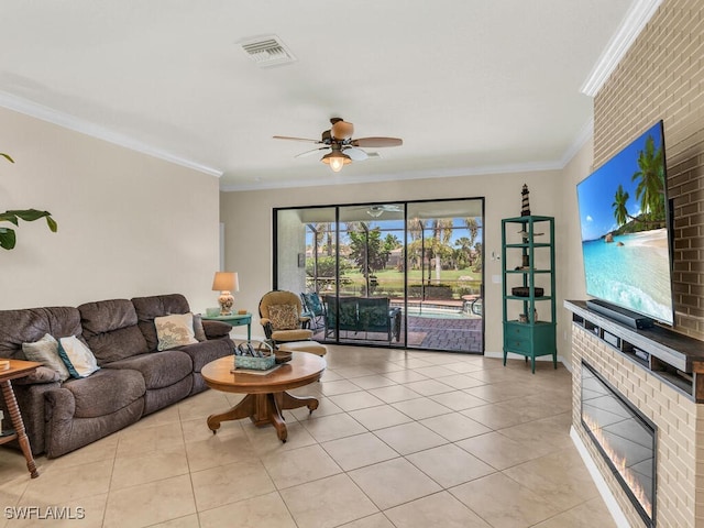 living area with visible vents, ceiling fan, ornamental molding, a brick fireplace, and light tile patterned flooring