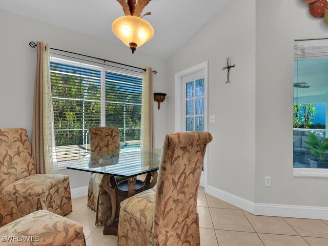 dining space featuring light tile patterned flooring and vaulted ceiling