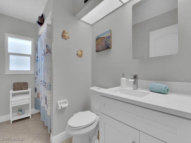 bathroom with toilet, vanity, and tile patterned flooring