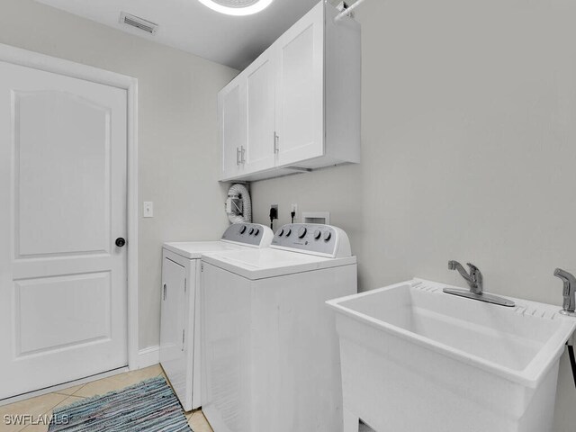 laundry room featuring cabinets, washer and clothes dryer, sink, and light tile patterned floors