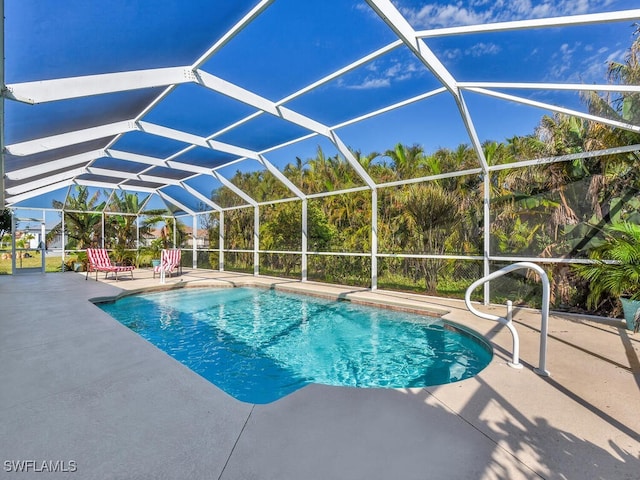 view of pool featuring glass enclosure and a patio area