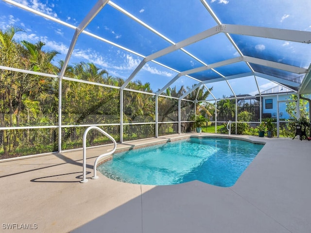 view of pool featuring glass enclosure and a patio area