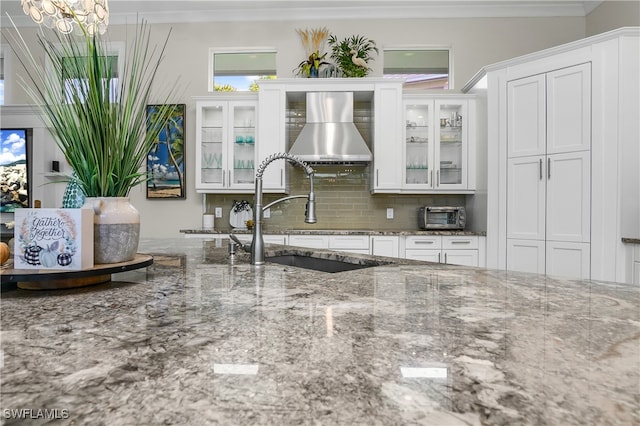 kitchen featuring white cabinetry, stone countertops, decorative backsplash, and sink