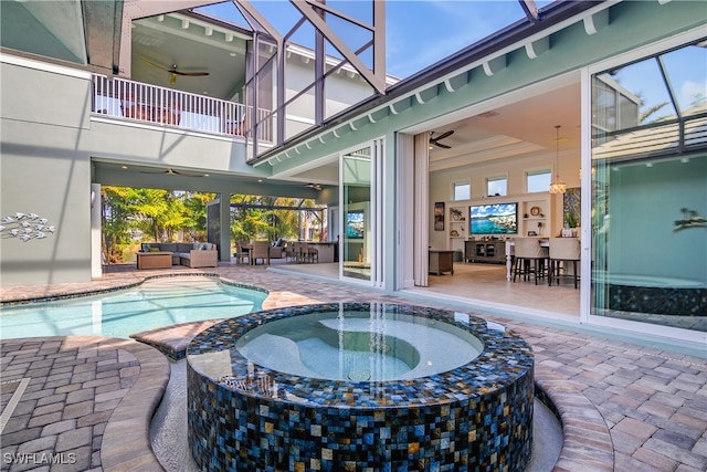 view of swimming pool featuring an in ground hot tub, a patio, glass enclosure, and ceiling fan