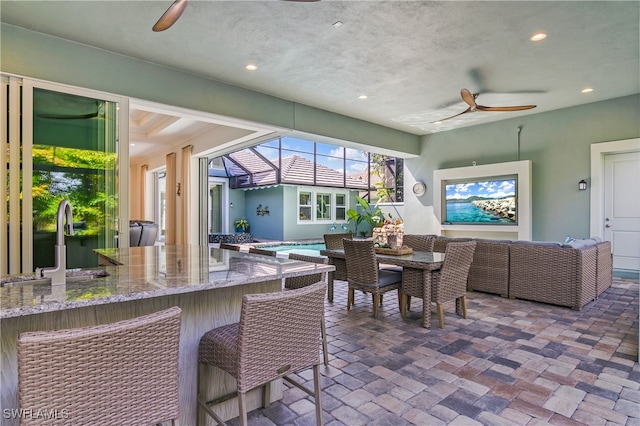 dining room with sink, a textured ceiling, and ceiling fan