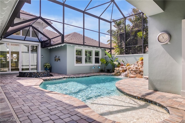 view of pool featuring pool water feature, a patio area, and glass enclosure