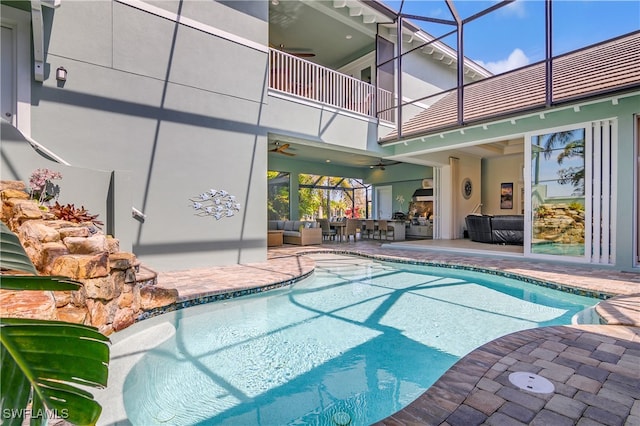 view of swimming pool with outdoor lounge area, a patio, and a lanai