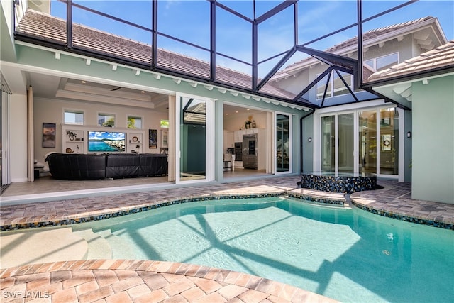 view of pool with ceiling fan, a patio, and a lanai