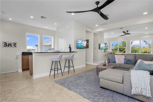 living room featuring ceiling fan and a healthy amount of sunlight