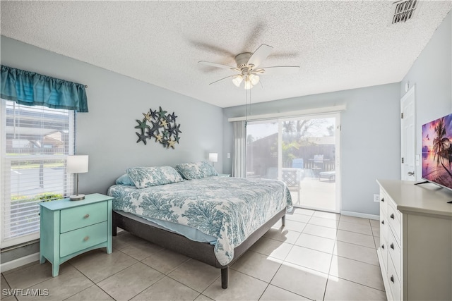 tiled bedroom featuring access to exterior, a textured ceiling, and ceiling fan