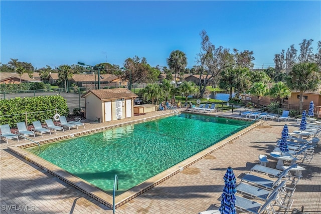 view of pool featuring a storage unit and a patio area