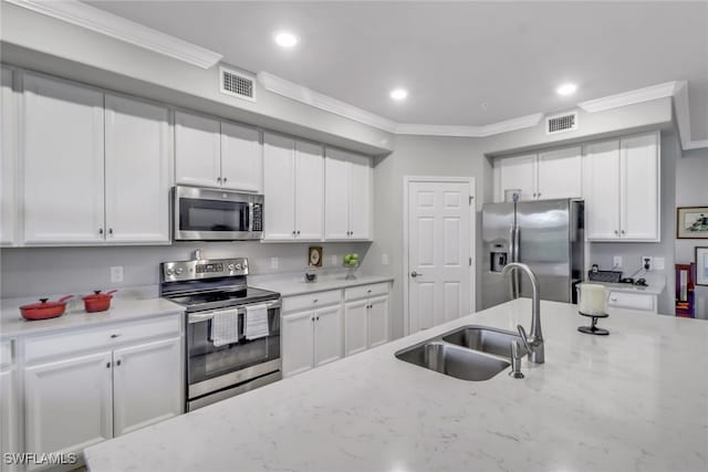 kitchen featuring stainless steel appliances, ornamental molding, light stone counters, and white cabinetry