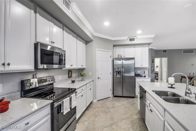 kitchen featuring crown molding, sink, light stone countertops, appliances with stainless steel finishes, and white cabinetry