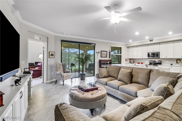 living room featuring ornamental molding, sink, and ceiling fan