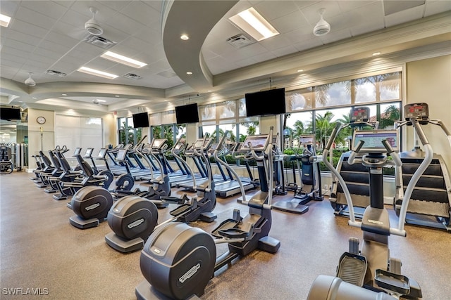 gym with a drop ceiling and crown molding