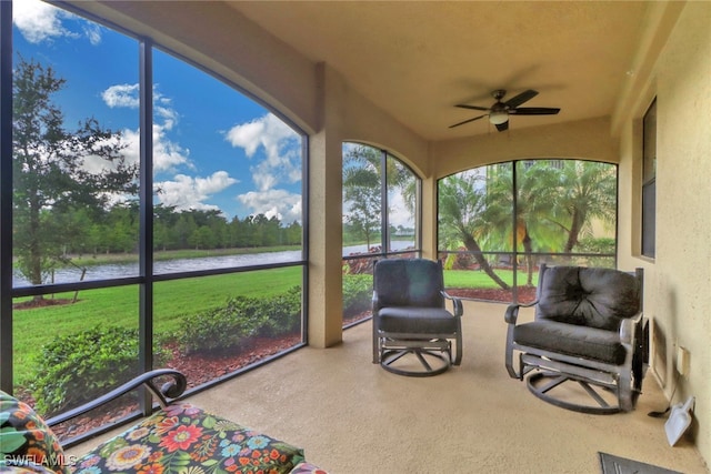 sunroom / solarium with a water view and ceiling fan