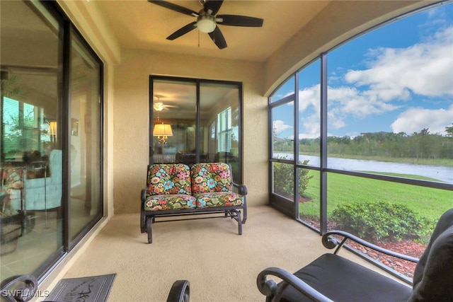 sunroom with a water view and ceiling fan