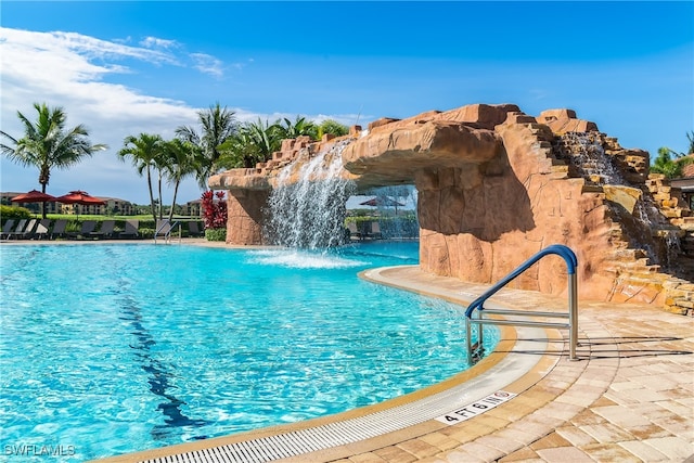 view of swimming pool with pool water feature