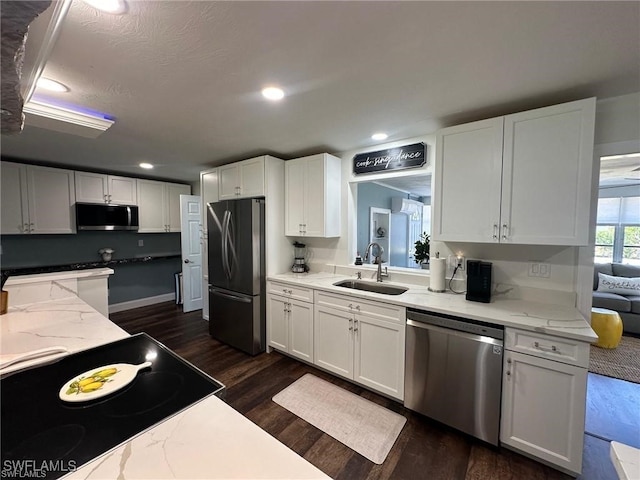 kitchen featuring dark hardwood / wood-style floors, stainless steel appliances, sink, white cabinets, and light stone counters