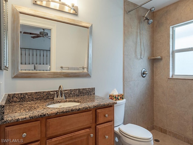 bathroom featuring plenty of natural light, tiled shower, toilet, and vanity