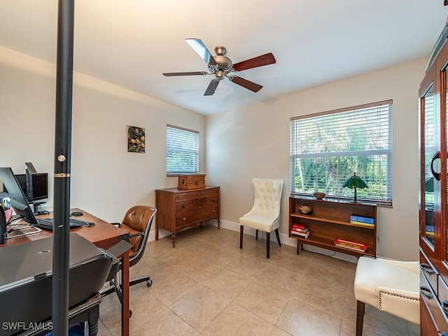 office space featuring a healthy amount of sunlight, ceiling fan, and light tile patterned floors