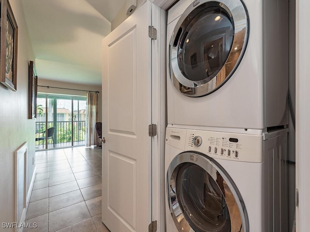 laundry area featuring stacked washer and dryer and light tile patterned floors