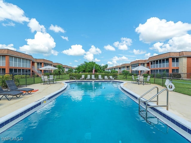 view of pool with a patio and a yard