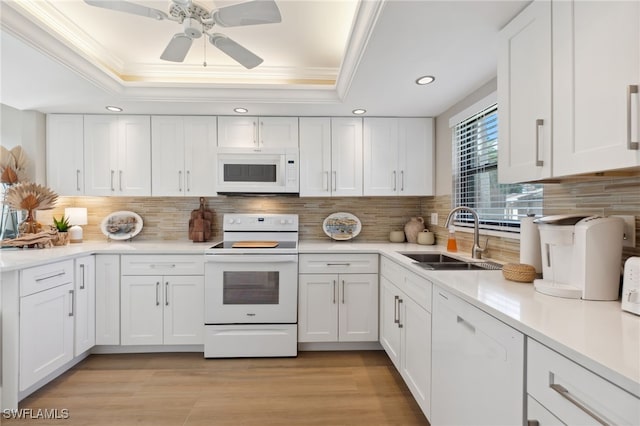 kitchen featuring white appliances, tasteful backsplash, white cabinetry, and sink