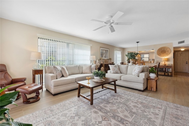 living room with light hardwood / wood-style floors, a healthy amount of sunlight, and ceiling fan