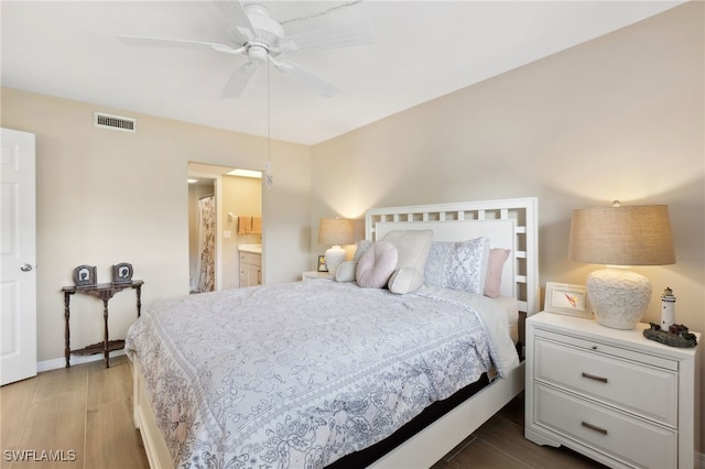 bedroom featuring ensuite bath, light wood-type flooring, and ceiling fan